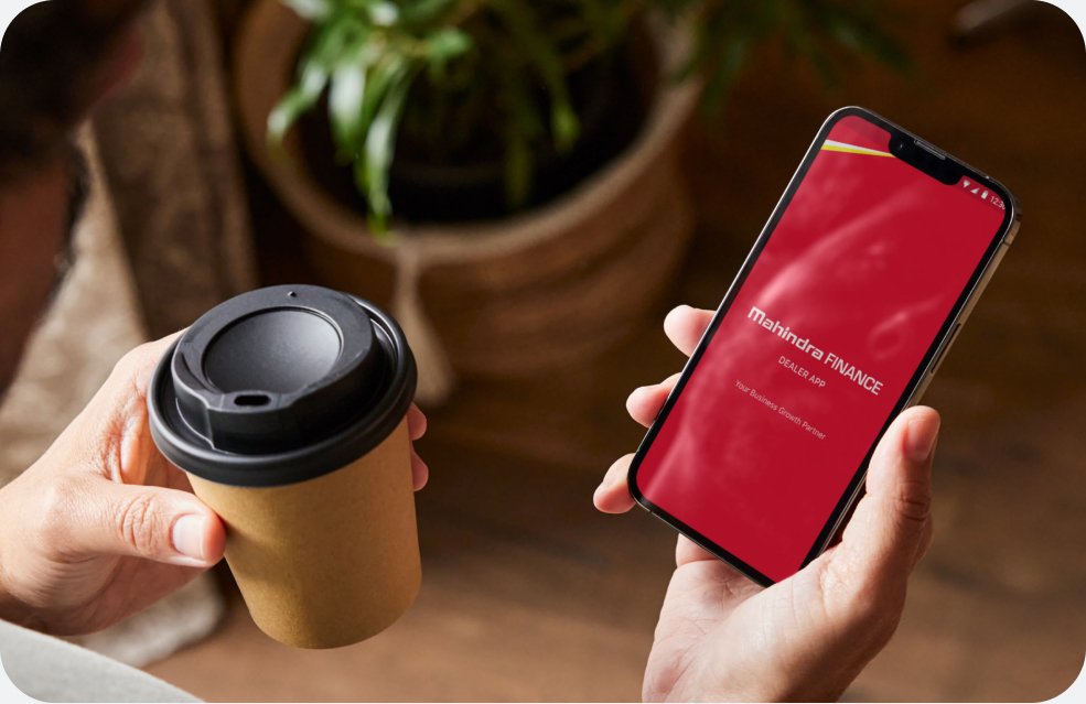 Mahindra Finance app — hand holding phone showing the digital lending platform